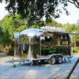 Custom airstream food trailer for sale with full-length service window, wood bar counter, and pendant lighting – Isabella Trailer