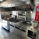 BBQ food truck interior with commercial griddle, charbroiler, oven, exhaust hood and fire extinguisher – fully equipped mobile kitchen for sale