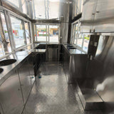 Commercial drink trailer interior featuring multiple service windows, stainless steel counters, sliding windows, and durable flooring
