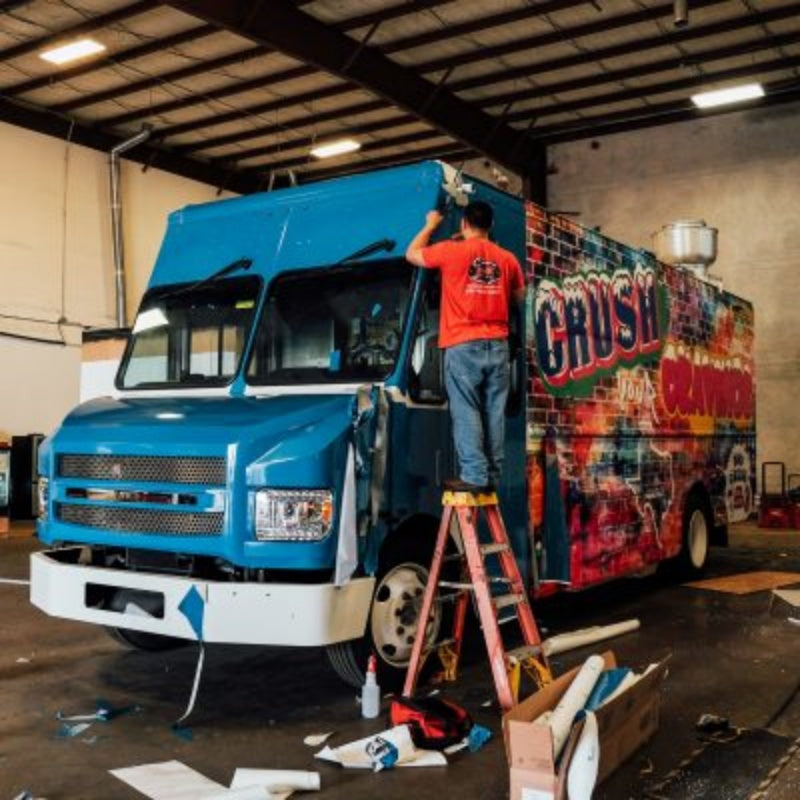 BBQ food truck custom vinyl wrap installation in workshop – fully customizable mobile catering truck for sale