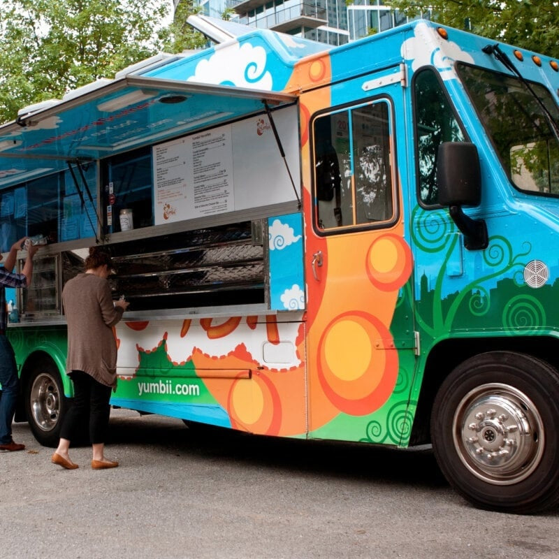 Custom wrap BBQ food truck with open serving window and customers ordering – mobile catering for sale