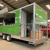 Green concession trailer for sale rear side view with open kitchen and rear storage area – custom food trailer ready for delivery