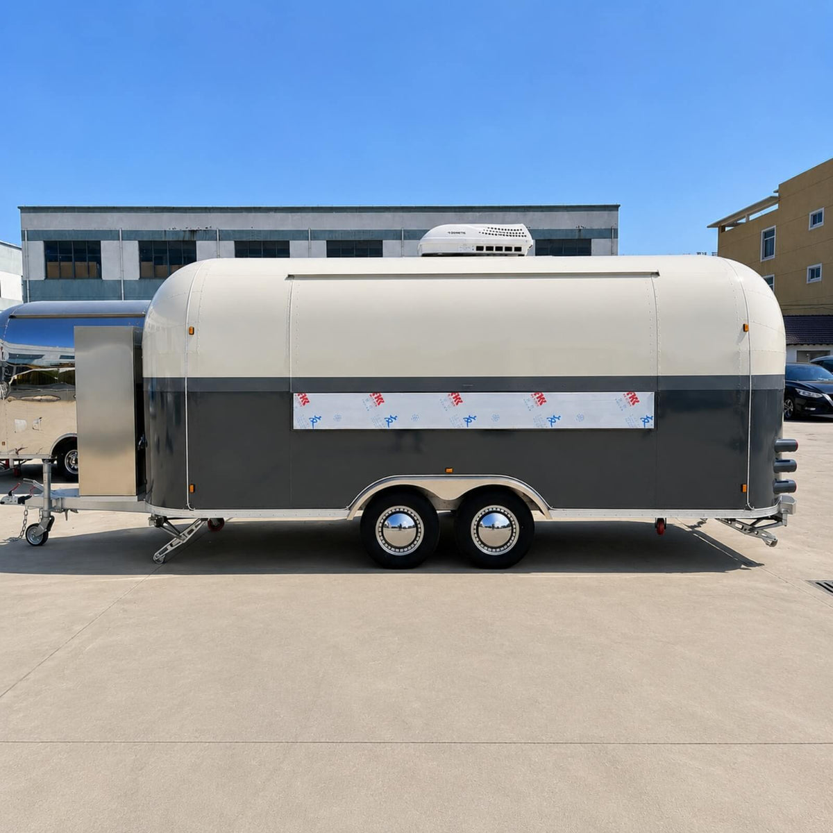 Custom Airstream food trailer side view closed – dark grey cream two-tone dual axle refrigeration unit by Isabella Trailer