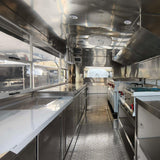 Custom square food trailer interior – full stainless steel commercial kitchen with exhaust hood and prep counters by Isabella Trailer