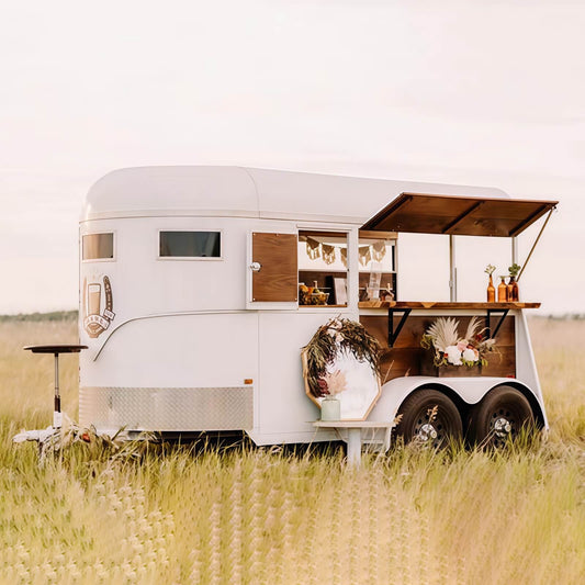 Custom white horse trailer mobile bar for weddings – fold-out canopy wood counter floral decor by Isabella Trailer