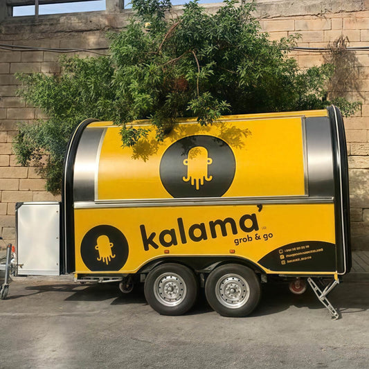 Custom rounded food trailer with yellow and black wrap and wide service window