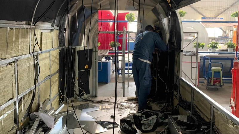 Technician installing electrical wiring inside airstream food trailer – Isabella Trailer factory