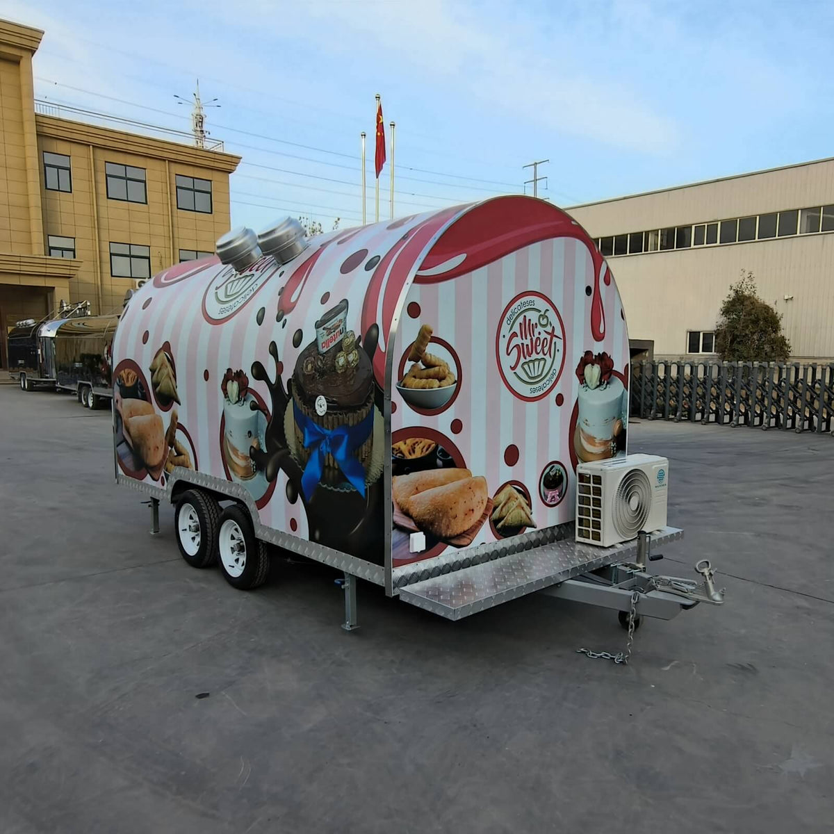 Mobile bakery trailer side view with custom wrap, stabilizer legs, and external air conditioning unit