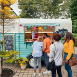 Vintage horse trailer food stall – teal color vegan street food customers queuing by Isabella Trailer